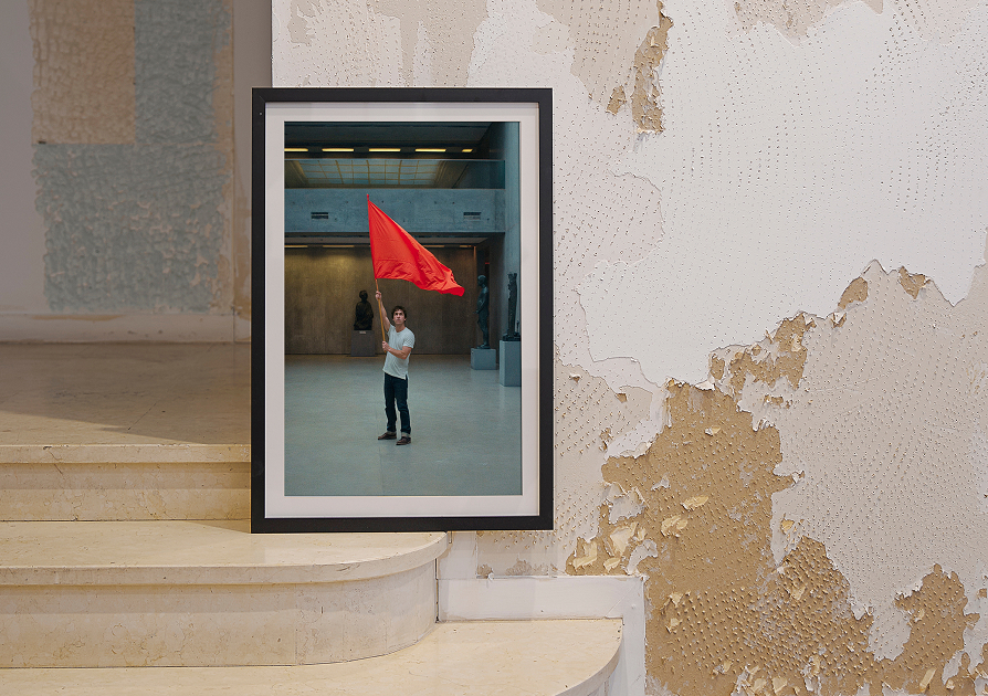 une image d'un homme portant un drapeau rouge dans un cadre posé sur un mur
